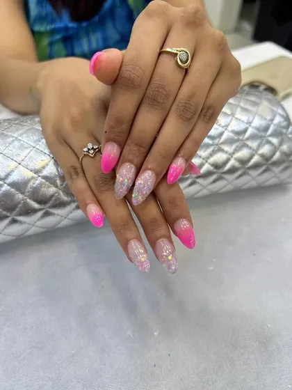 A fun and vibrant pink ombre design with glitter accents. This showcases the creative and trendy styles our students learn.