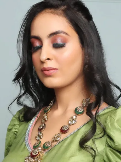 A close-up of an engagement look. The focus is on a colorful smokey eye that complements the green outfit and traditional jewellery.