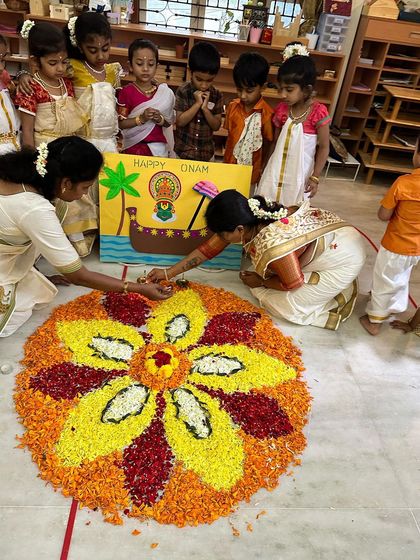 Little hands carefully place petals as our teachers guide them in creating a magnificent pookalam, a true hands-on cultural activity.