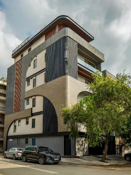 An angled view of the Patel Nagar project, where clean geometry meets subtle drama. The design plays with different materials and textures within a curved framework to create a unique and modern look.