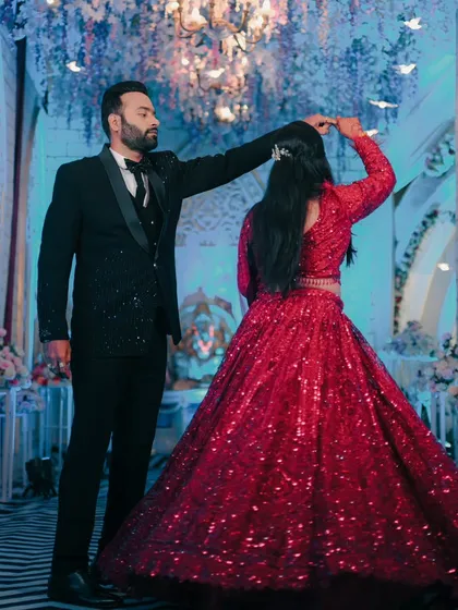 The first dance as husband and wife. We captured this beautiful moment of the groom twirling his bride in her stunning red reception gown.