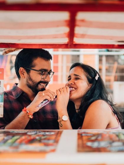 Sharing a laugh at a street food stall, this candid pre-wedding photo captures the simple joys of being together. We believe the best moments are often the most ordinary ones.