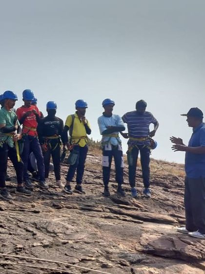 An instructor briefs a group of climbers at the top of a cliff in Badami. Clear communication and expert instruction are key to our advanced training programs.