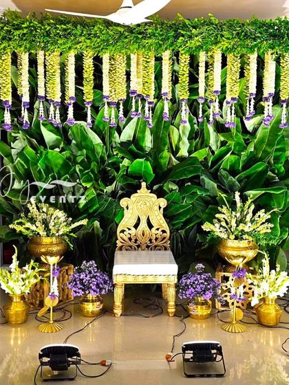 For this traditional half saree function, we used a lush backdrop of fresh banana leaves and hanging garlands of jasmine. The decor is accented with purple flowers and traditional brass vases for an authentic and rich look.