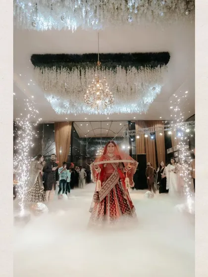The bride, Shalini, makes a grand entrance through a cloud of smoke and sparklers, a truly magical and cinematic moment.