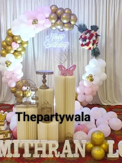 A simple and elegant ring backdrop with pink, white, and gold balloons. The long light-up name sign is perfect for celebrating two people at once.