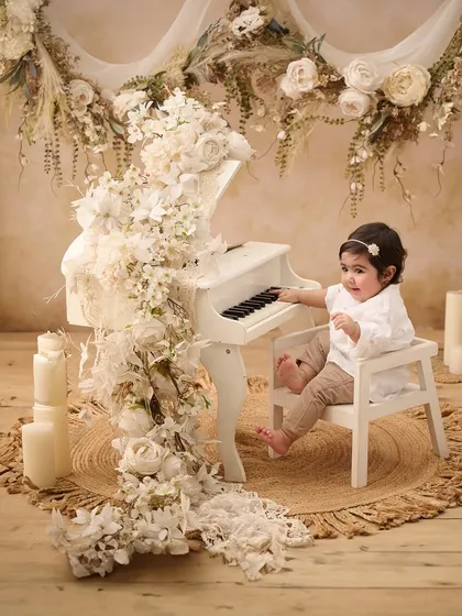 Our studio is filled with unique props like this miniature white piano, allowing us to create elegant and artistic portraits that highlight your baby's curious nature.
