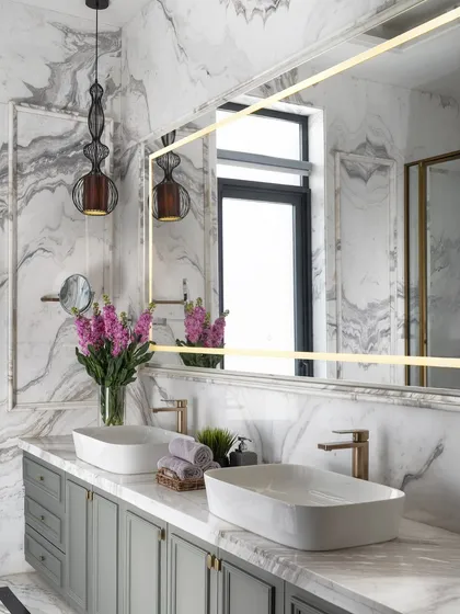 Luxury lies in the details. In this master bathroom, we paired dramatic book-matched Italian marble with a custom sage green vanity and brushed gold fixtures. The result is a serene and sophisticated sanctuary, proving that functional spaces can also be exceptionally beautiful.