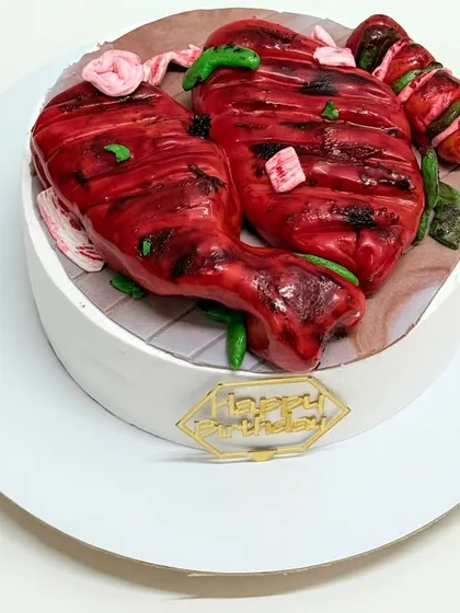 A cake that looks surprisingly like tandoori chicken on a grill. Everything on this cake is 100% edible, making it a fun and quirky choice for a foodie.
