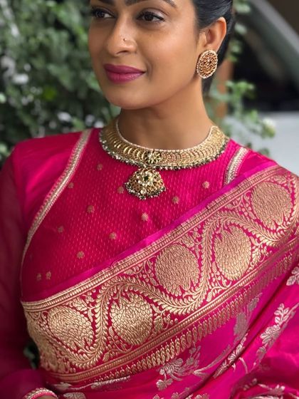 This client chose a vibrant pink brocade blouse with a high neckline. The design is both modern and traditional, perfect for pairing with a statement necklace.