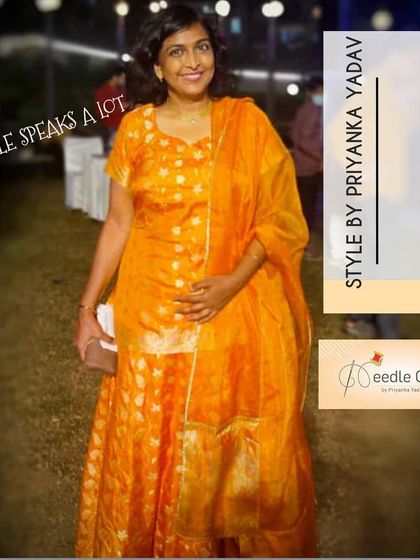 A happy client in a bright orange brocade suit set, custom-stitched for a perfect fit for a festive occasion.