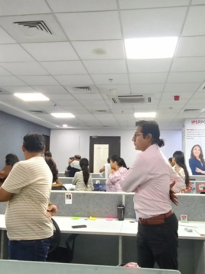 Employees practicing a standing stretch to release tension in the shoulders and back. Taking short breaks for movement is crucial for maintaining energy and preventing stiffness.