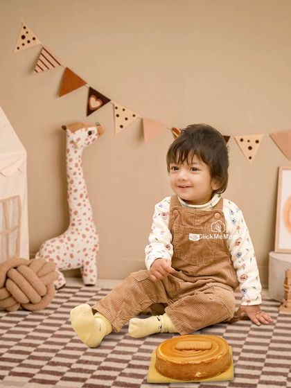 A cozy and rustic cake smash with a woodland animal theme. The warm, earthy tones and cute giraffe prop create a gentle and charming setting for a first birthday.