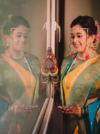 Another angle of the reflection shot, capturing the bride's serene expression as she anticipates the ceremony. Her makeup looks flawless even in the soft light.