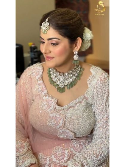 My lovely bride showing off her elegant floral and pearl bun, a perfect choice for her pastel lehenga.