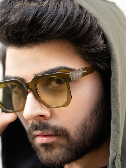 An edgy close-up focusing on unique eyewear and a hooded jacket. This type of shot is great for showcasing accessories and building a cool, urban-inspired brand image.