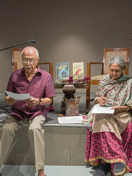 A theatrical reading in progress. Performers sit on stage, bringing a script to life for an attentive audience.