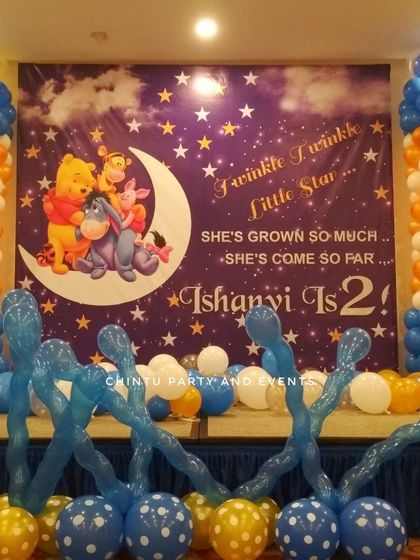 A "Twinkle Twinkle Little Star" second birthday party featuring Winnie the Pooh characters. The decor uses a starry night backdrop and balloon pillars in blue, white, and orange.