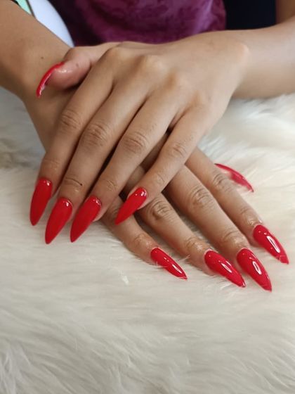 A recap photo of a bold, classic red on long stiletto nails.