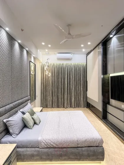 This shot focuses on the TV and storage unit opposite the bed. The sleek, handle-less design and combination of materials create a clean and modern look, ensuring the room remains clutter-free.