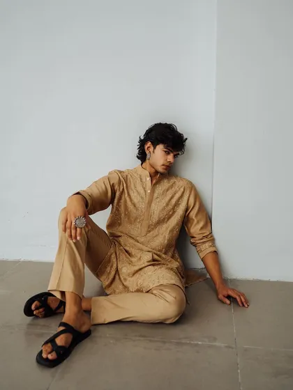 A simple, grounded shot for the Wabi Sabi lookbook. The seated pose and neutral tones of the kurta create a calm and earthy aesthetic.