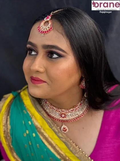 A classic portrait of a reception look, featuring a ruby and diamond jewelry set that complements the pink and green saree.