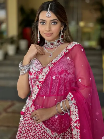 A beautiful bride in a vibrant pink lehenga. The makeup is soft and glamorous, with defined eyes and a flawless base, showcasing the magic of my hands.