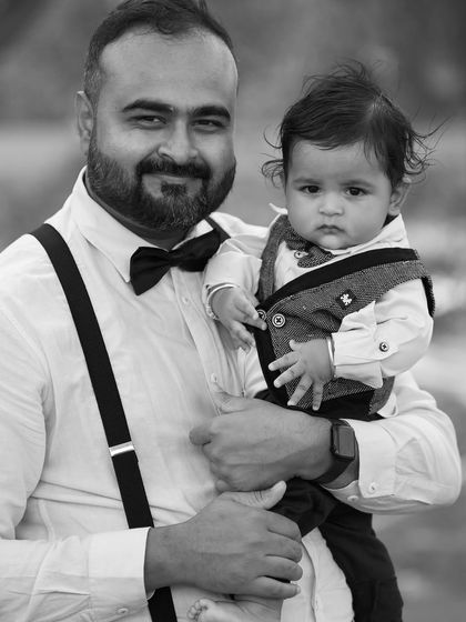 A classic father and son portrait in black and white. The formal attire and direct gaze give this image a distinguished, timeless quality.