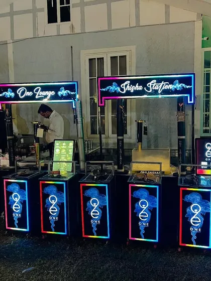 Our modern, portable hookah stations are perfect for sangeets and cocktail parties. This setup includes multiple LED-lit hookah counters, neon signage, and dedicated staff to manage the service.