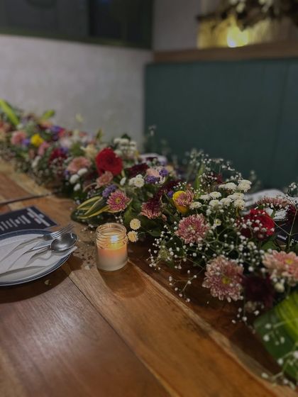 The candlelight mixed with fresh flowers creates a warm and inviting ambiance for an evening celebration.