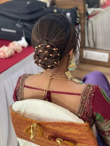 For this wedding bun, I used a braided style and wove a traditional gold thread through it. It's a classic look that is both intricate and elegant.