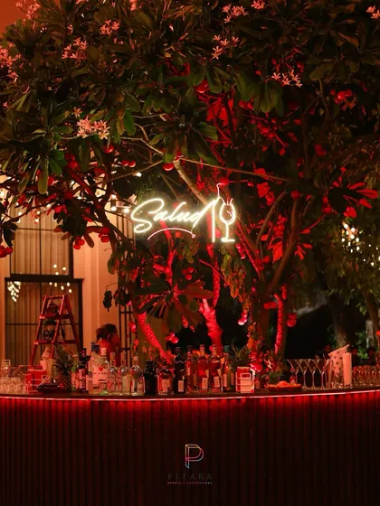 A bar should be a statement piece. For this event, we built the bar around a blooming tree, adding a custom neon sign and dramatic red uplighting to make it a central hub that was both functional and visually striking.