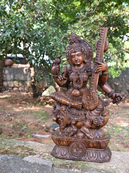 The Abhinaya Saraswathi statue shown in a garden setting, highlighting its artistic quality.