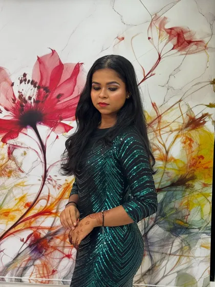 A candid shot of the model in a shimmering green dress. The makeup is designed to catch the light beautifully, making her stand out in any setting.