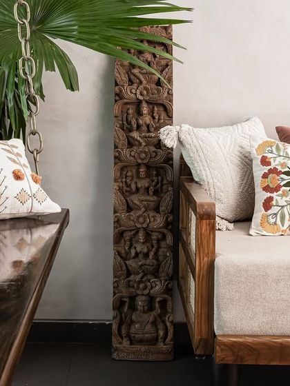 We love to mix textures and patterns. Here, embroidered cushions sit on a modern daybed and a traditional wooden swing, anchored by a beautifully carved antique wooden pillar.