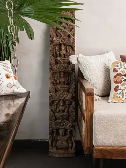 We love mixing textures and patterns. Here, a traditional wooden swing and sofa are adorned with embroidered cushions, placed next to an antique carved wooden panel.