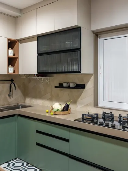 A pop of color makes this kitchen feel fresh and modern. The mint green lower cabinets are paired with neutral upper cabinets and a playful black-and-white tiled floor, creating a space that is full of personality.