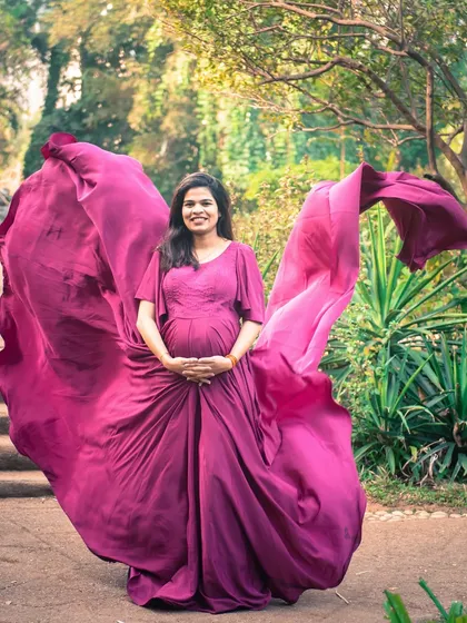 The wind catches the fabric of this magenta gown, creating a beautiful, dynamic shot that celebrates the mom-to-be.