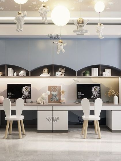 A shared study area for the little ones. This design is both playful and functional, with bunny-eared chairs, astronaut figures hanging from the ceiling, and plenty of organized desk space for two.