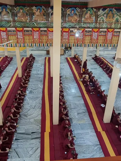 A view of the vast prayer hall during a ceremony at Sera Jey Monastery, filled with the Sangha community engaged in collective practice. This image captures the scale and serene dedication of monastic life.