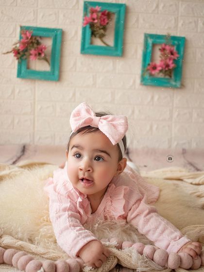 Tummy time during a six-month session! Her expressive face and the soft pink tones make for an adorable baby portrait.
