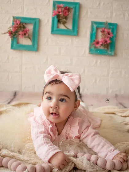 A sweet baby girl crawling on a soft fur rug during her six-month sitter session.