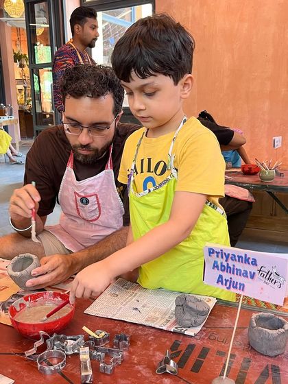 A father and son add the finishing touches to their pot. It's these moments of focused teamwork that make our family workshops so meaningful.