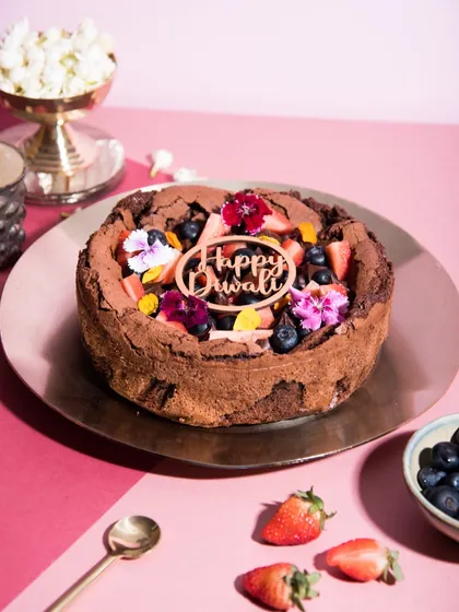 My classic flourless chocolate cake, decorated for Diwali with fresh berries, edible flowers, and a festive topper. It's rich, indulgent, and naturally gluten-free.