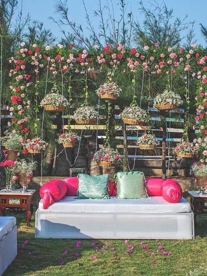 An outdoor seating backdrop with a rustic feel. I created a wall of hanging flower baskets behind a comfortable diwan for a relaxed and beautiful photo spot.