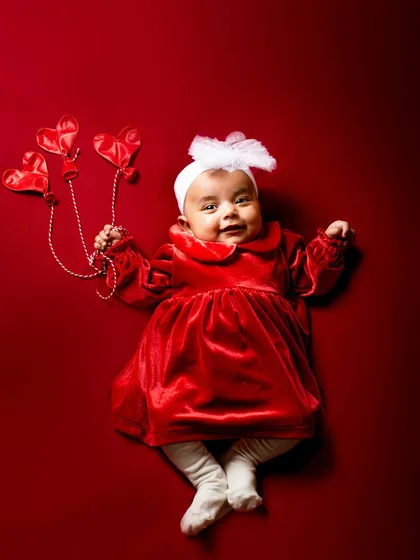 A beautiful portrait of a baby girl in a red velvet dress. This simple, elegant setup is perfect for capturing the sweetness of your little one at any age.