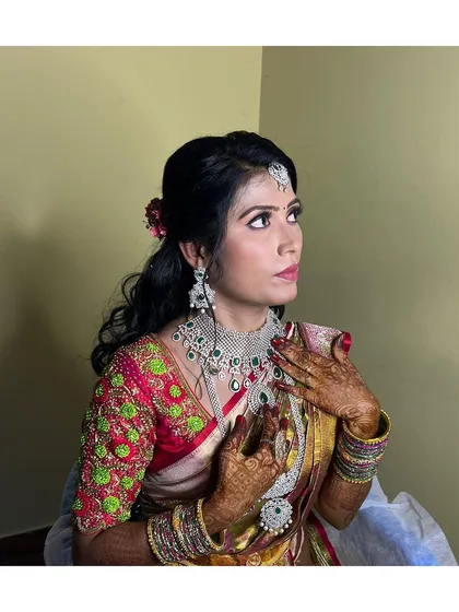 This reception look is all about modern elegance. The focus is on luminous skin, soft-glam eyes, and a vibrant lip, perfectly complementing her diamond and emerald jewelry. This style is designed to look incredible both in person and in photos.