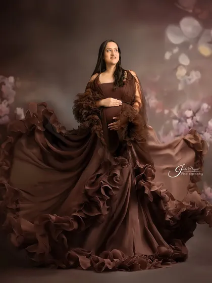 The movement of the fabric brings this portrait to life. The expecting mother, in a flowing brown gown, looks off to the side as the dress swirls around her.