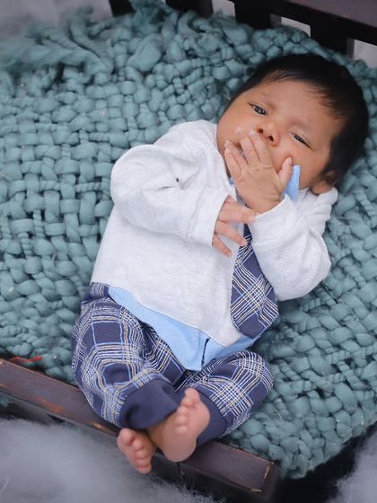Dressed up and ready for his close-up. This newborn is styled in a cute outfit, showing how we can add a touch of personality to your baby's first photoshoot.