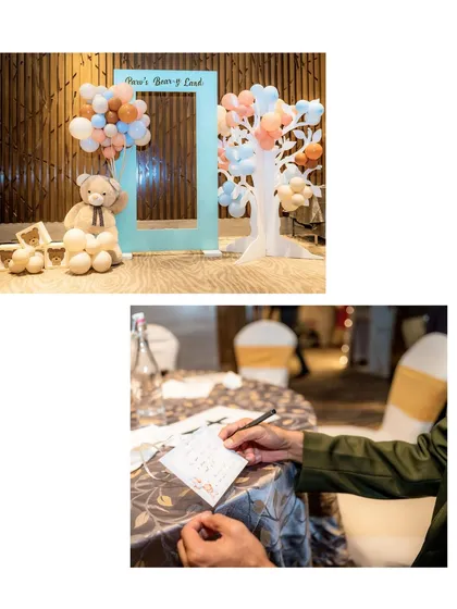 This image shows the "Beary Land" photo frame alongside a guest writing a message, highlighting both the decor and the interactive elements of the party.